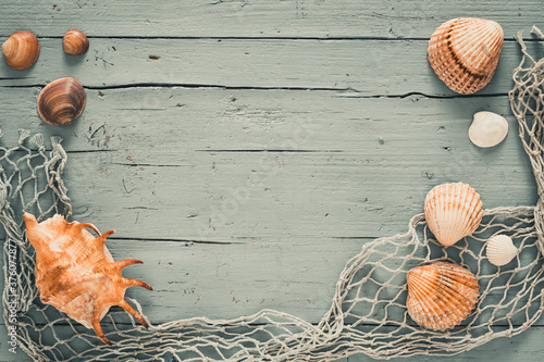 Fototapeta Naklejka Na Ścianę i Meble -  Seashells and fishing net on old grey wooden background