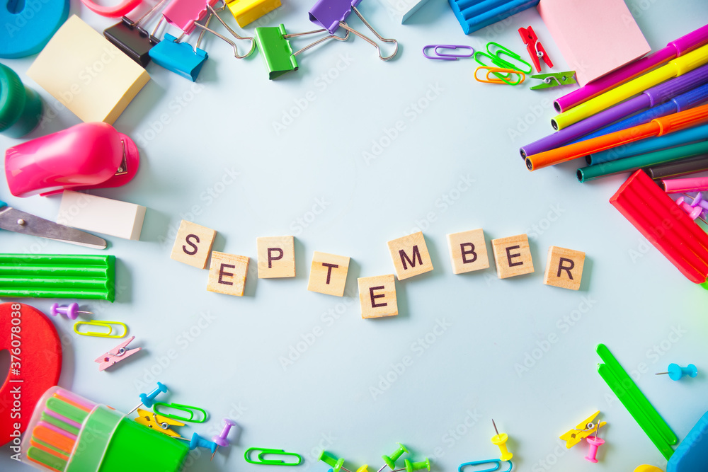 School supplies frame with text September on the light background. Top view. Copy space. School supplies frame with text September on the light background. Top view. Copy space.