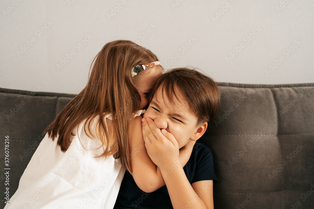 Girl whispers boy in the ear a secret. Childrens gossip Girl whispers boy in the ear a secret. Childrens gossip