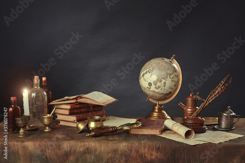 Desktop of a scientist, writer, or student of past centuries. Vintage items, books and manuscripts on a dark background. Space for your text. photo