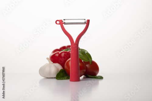 Red vegetable peeler on white background © Stasys
