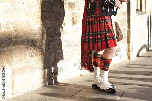 Man In Traditional Scottish Dress From Waist Down In Front Of A Wall
