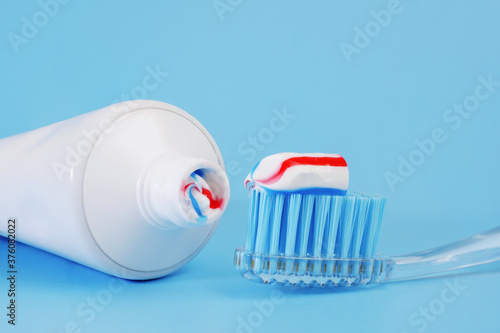 Obraz na płótnie toothbrush with toothpaste on it and white toothpaste tube on blue background