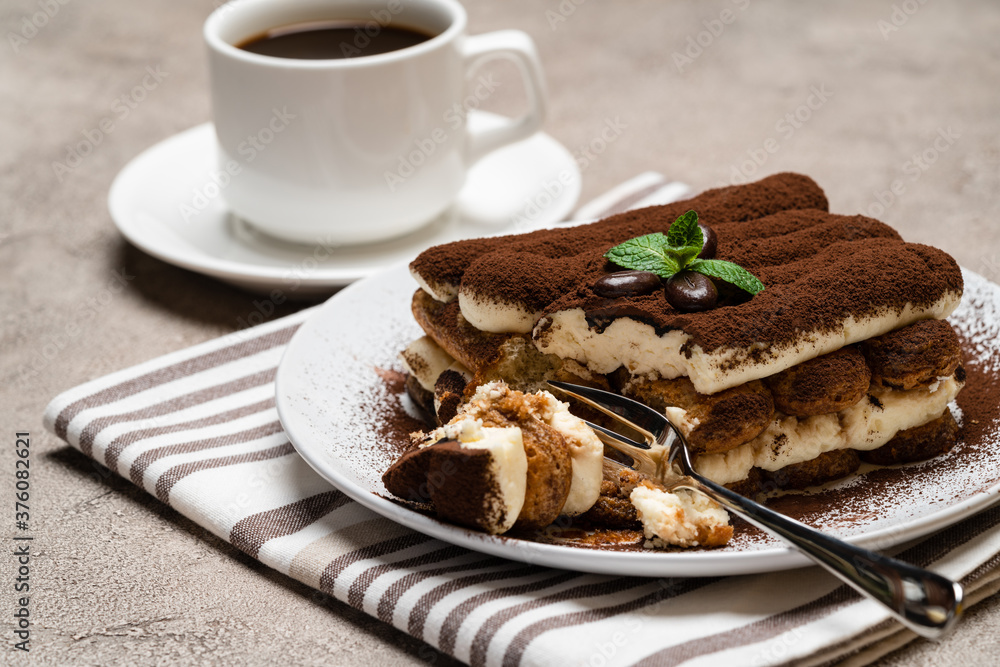 portion of Classic tiramisu dessert and cup of fresh espresso coffee on concrete background portion of Classic tiramisu dessert and cup of fresh espresso coffee on concrete background