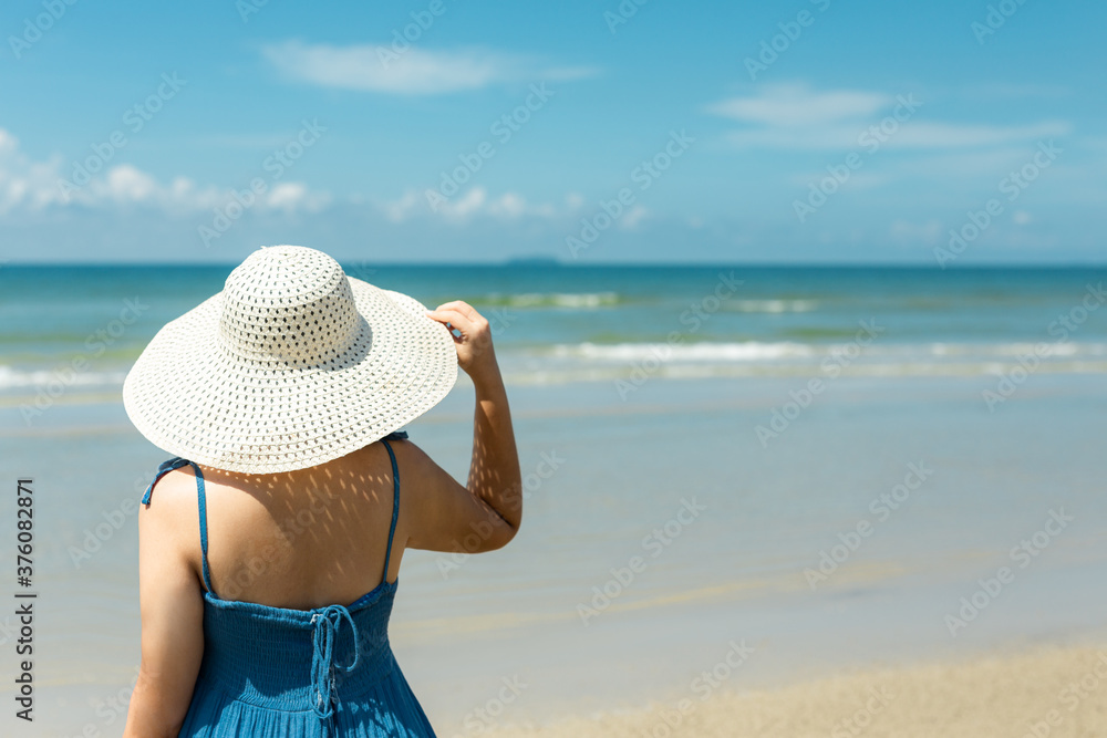  asian woman in blue dress in summer on the sand on the beach of tropical island.
