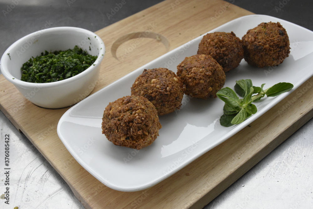 Falafels recién salidos de la sartén. Mezcla del perejil con la cebolla, el ajo, comino molido, pimienta negra, aceite de oliva, sal, cilantro y harina de quinua. Falafels recién salidos de la sartén. Mezcla del perejil con la cebolla, el ajo, comino molido, pimienta negra, aceite de oliva, sal, cilantro y harina de quinua.