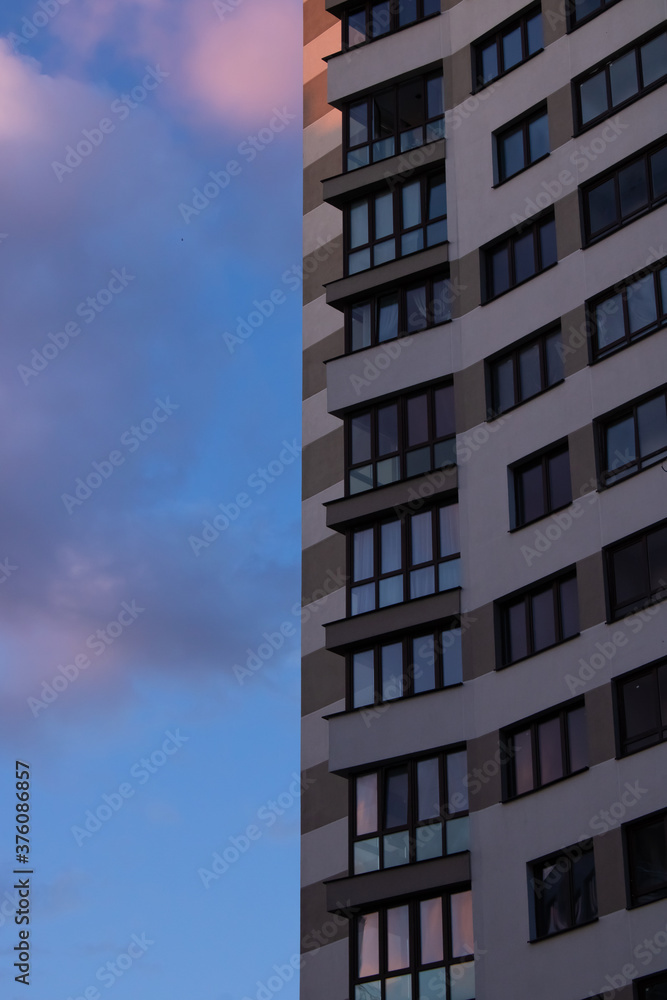 Facade of a modern light building on a blue sky background
