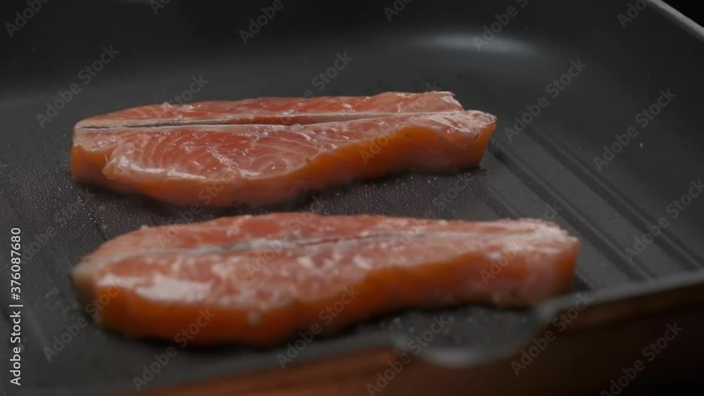 Close up professional chef grilling red fish fillet steak. Slow motion Close up professional chef grilling red fish fillet steak. Slow motion