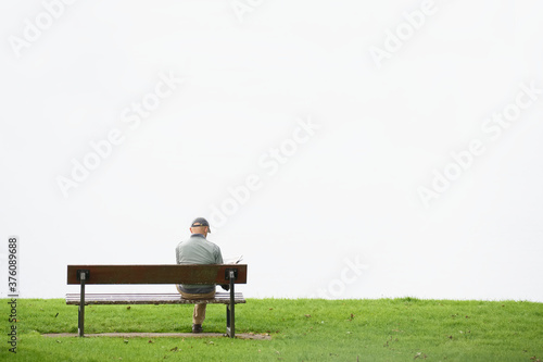 Social distancing single man alone on seat outdoors