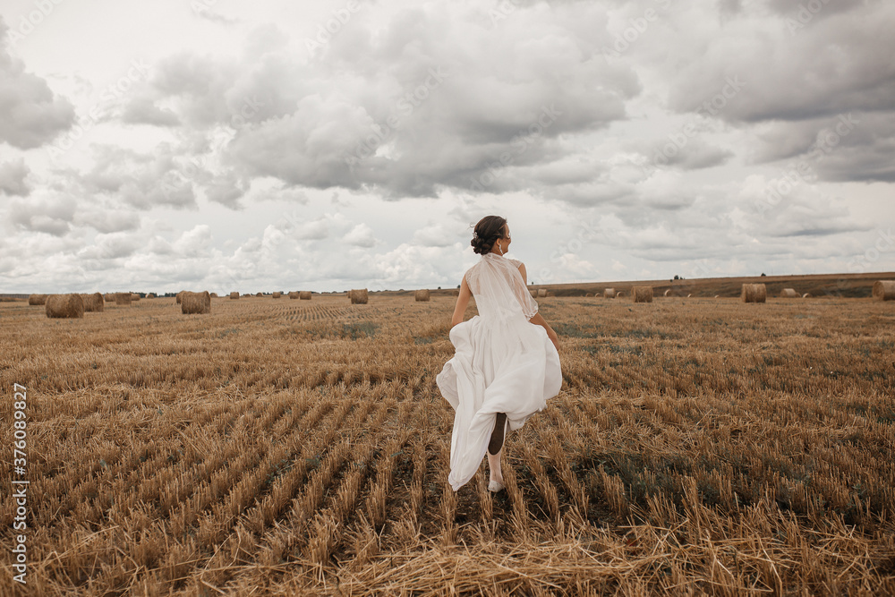 a bride in a wedding dress runs across the field a bride in a wedding dress runs across the field
