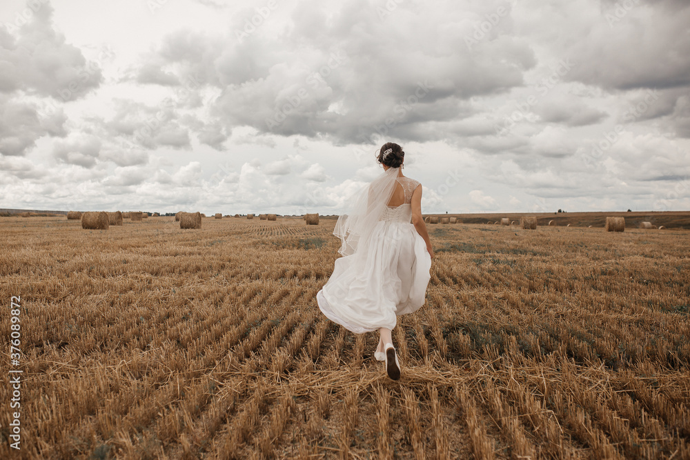 a bride in a wedding dress runs across the field a bride in a wedding dress runs across the field