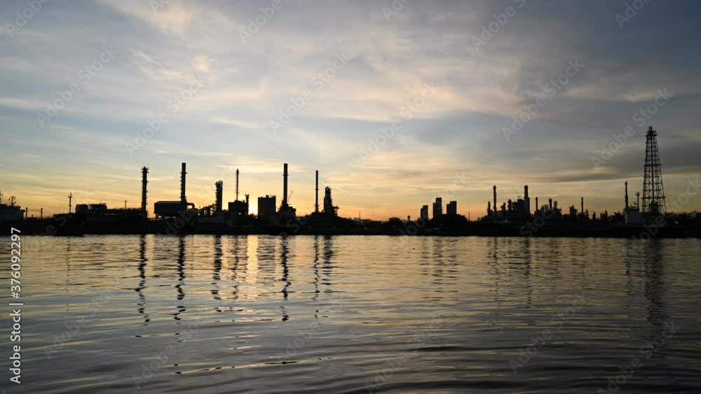 Silhouette oil refinery plant from industry petrochemical oil and gas refinery and pipeline industry with sunrise sky background. Silhouette oil refinery plant from industry petrochemical oil and gas refinery and pipeline industry with sunrise sky background.