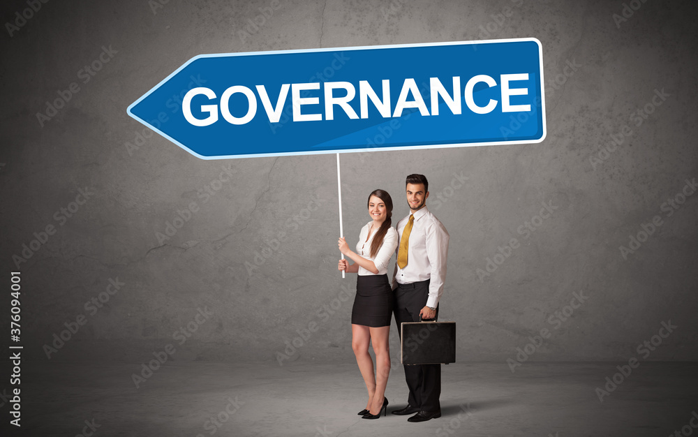 Young business person in casual holding road sign with GOVERNANCE inscription, new business direction concept Young business person in casual holding road sign with GOVERNANCE inscription, new business direction concept