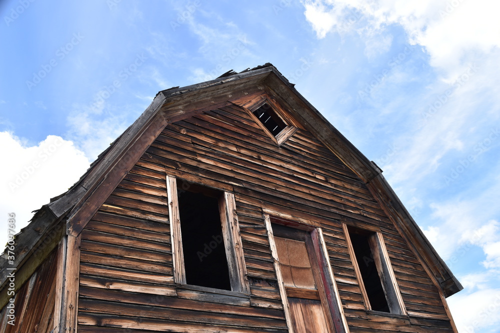 Old abandoned wooden house or barn. Empty, broken windows. Old abandoned wooden house or barn. Empty, broken windows.