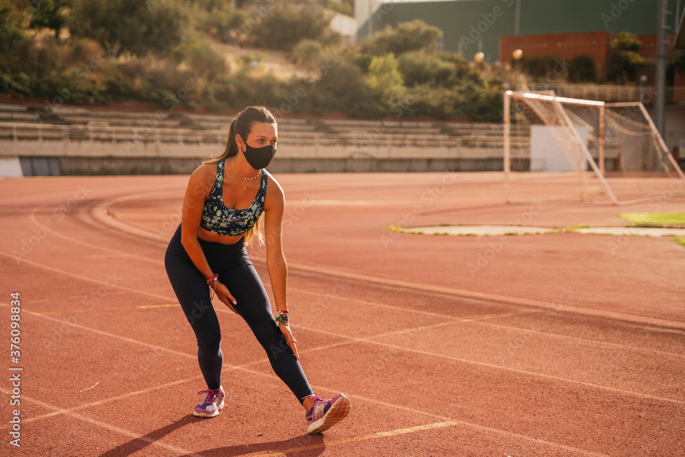 Young girl stretching legs before training with mask