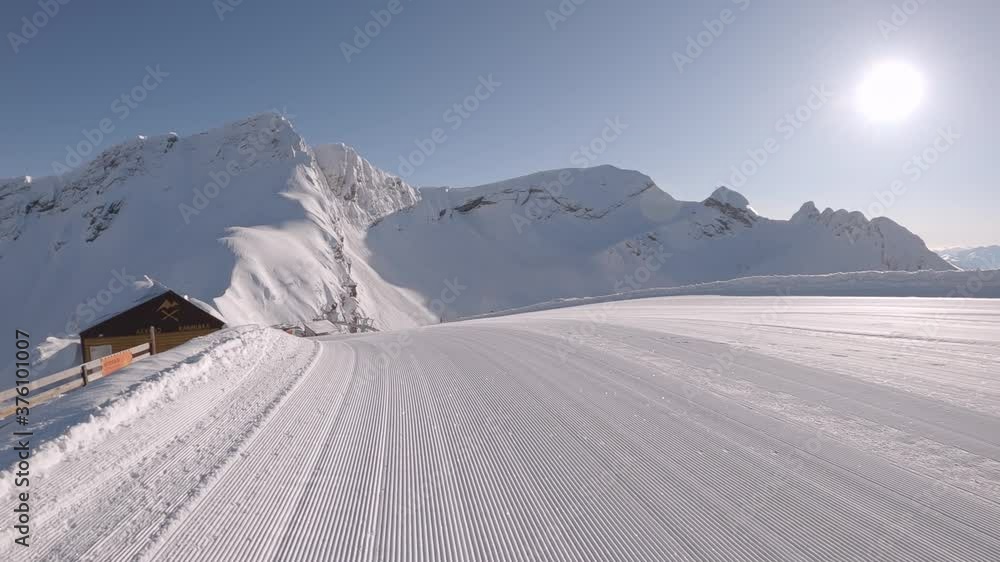panorama of the ski slope with a prepared route in the early morning, without traces of skiers, rescue cabin. Perfectly groomed snow. 2K RAW video footage panorama of the ski slope with a prepared route in the early morning, without traces of skiers, rescue cabin. Perfectly groomed snow. 2K RAW video footage