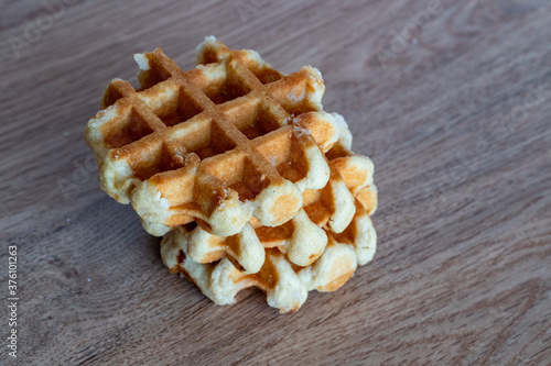 Obraz na płótnie A delicious baked round Belgian waffle with one bite taken. w salonie