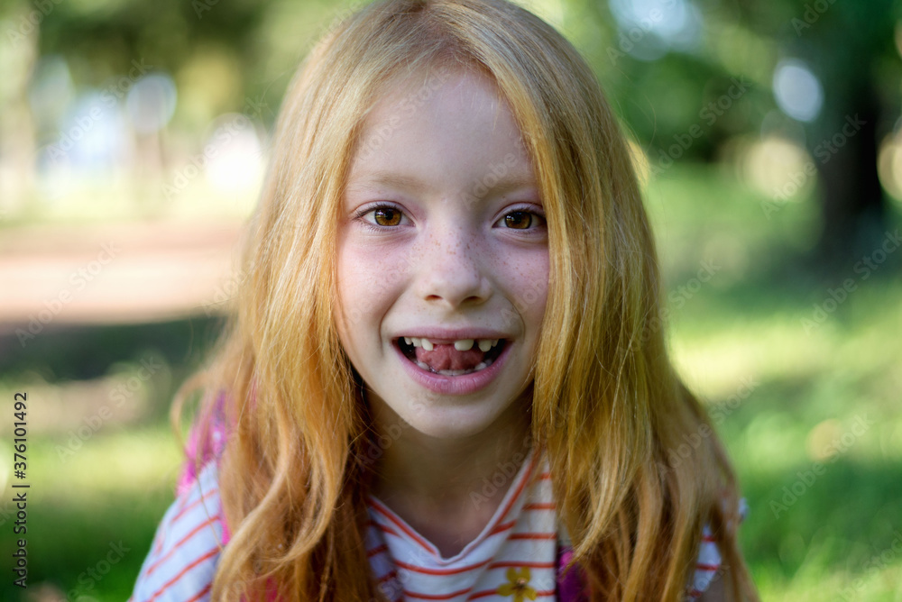 Cute redhead girl shows her tooth Cute redhead girl shows her tooth