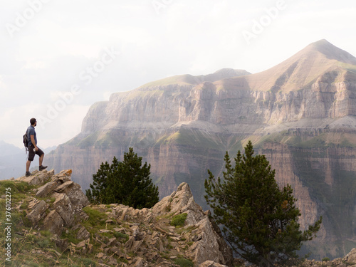 Person on the edge of a cliff looking at the mountains in the pyrenees