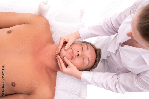 Woman doing massage on face of male client
