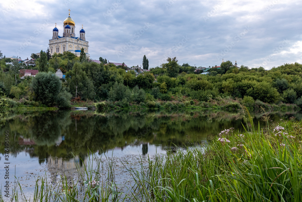 Russia, the city of Yelets, view of the Sosna river and the Cathedral of the ascension of the Lord under a cloudy sunset sky.