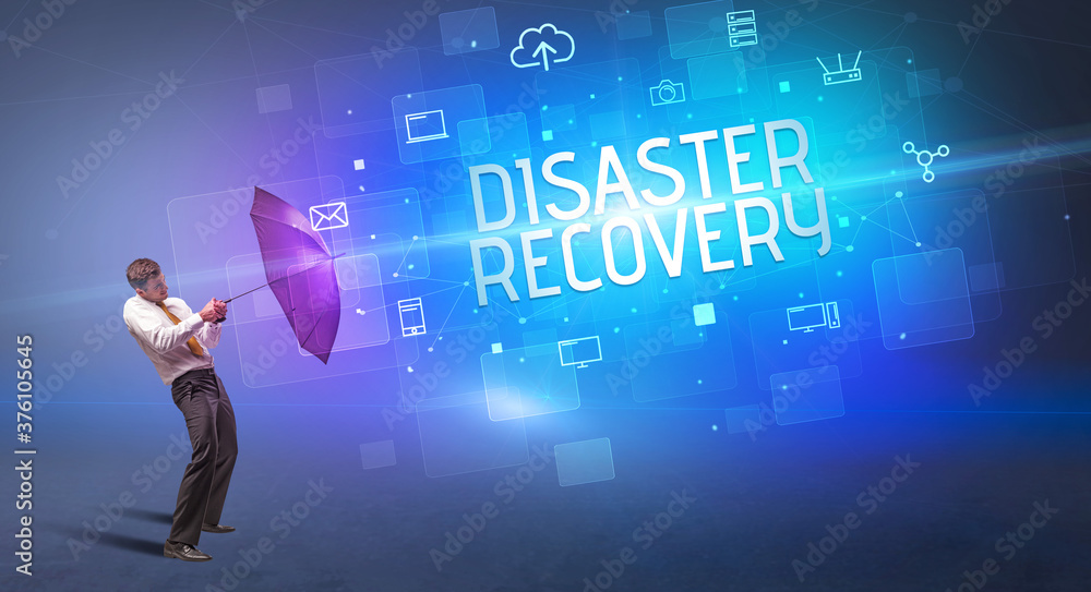 Businessman defending with umbrella from cyber attack and DISASTER RECOVERY inscription, online security concept Businessman defending with umbrella from cyber attack and DISASTER RECOVERY inscription, online security concept