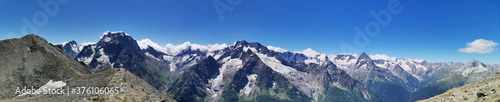 Picturesque mountain panorama with blue sky and mountain peaks in snow on a clear summer day, Dombay