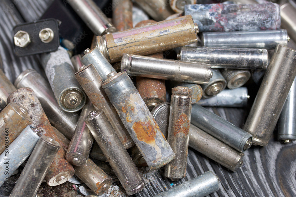 Corroded used batteries. On pine boards. Disposal of hazardous waste. Corroded used batteries. On pine boards. Disposal of hazardous waste.