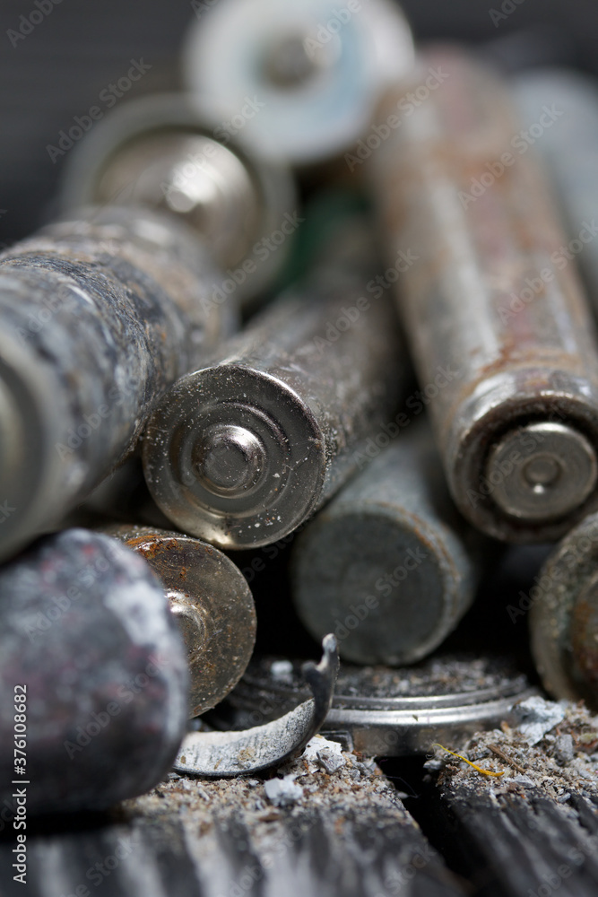 Corroded used batteries. On pine boards. Disposal of hazardous waste. Close-up shot. Corroded used batteries. On pine boards. Disposal of hazardous waste. Close-up shot.