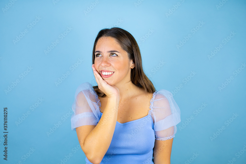 Young beautiful woman over isolated blue background ouching mouth with hand with painful expression because of toothache or dental illness on teeth Young beautiful woman over isolated blue background ouching mouth with hand with painful expression because of toothache or dental illness on teeth