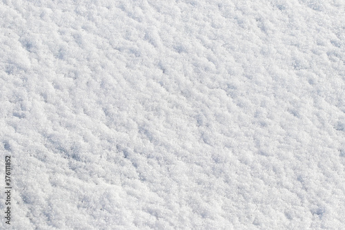 Texture of white snow that lies evenly on the ground