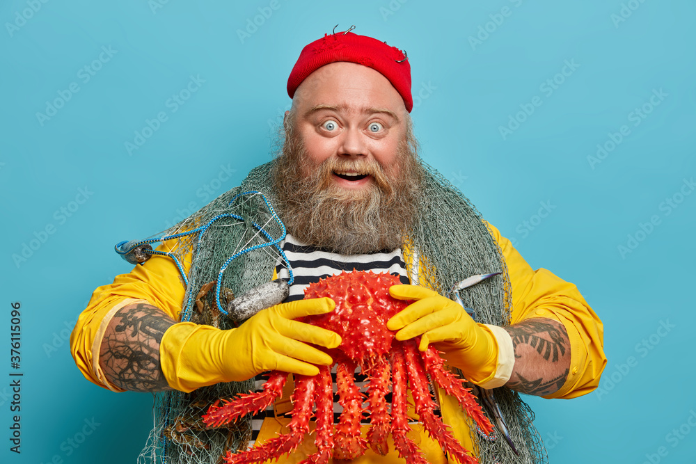 Image of happy positive lobsterman glad to catch big octopus, enjoys