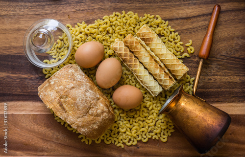 Bakery ingredients - bread, eggs, wafer rolls, Cezve, pasta on wood table. Sweet pastry baking concept. Flat lay, copy space, top view.