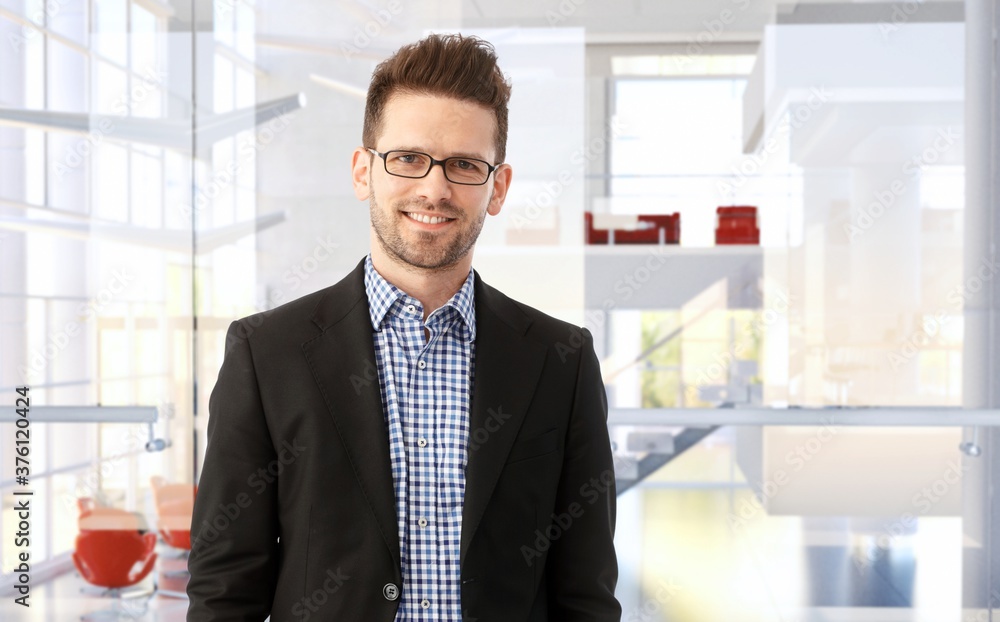 Portrait of a smiling trustworthy businessman in modern office building. Portrait of a smiling trustworthy businessman in modern office building.