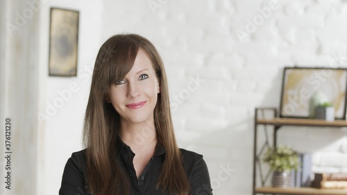 Portrait of confident woman at home, smiling in front of casual home indoor. 