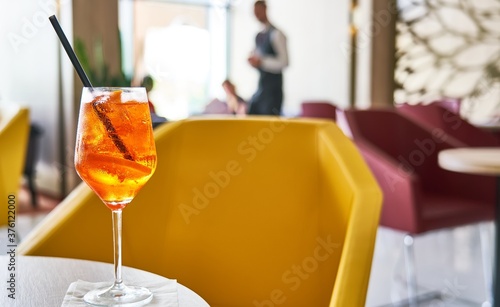 Glass of cold refreshing aperol spritz cocktail on table in summer.  