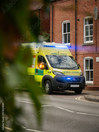 British Ambulance, Parked At The Side Of The Road During The Day - Lights Flashing