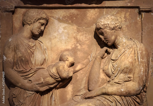 фотографія Ancient Greek bas-relief on grave stele, marble sculpture of women and child,