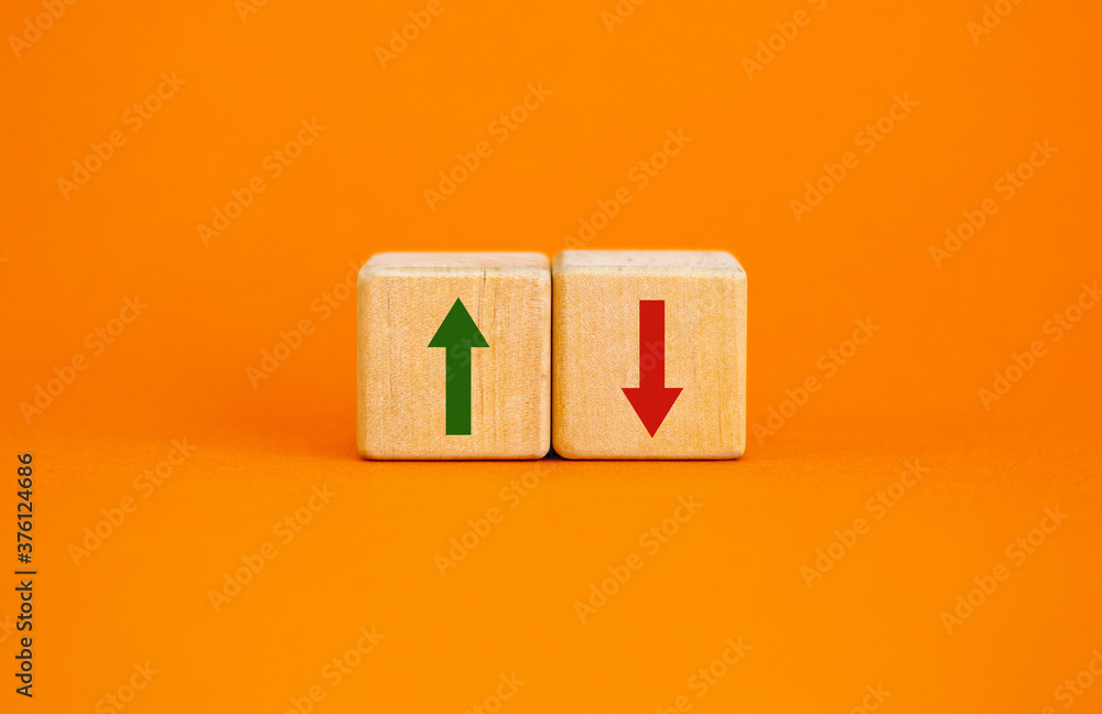Conceptual image of choice and direction. Wooden cubes with arrows pointing in opposite directions. Beautiful orange background, copy space. Conceptual image of choice and direction. Wooden cubes with arrows pointing in opposite directions. Beautiful orange background, copy space.