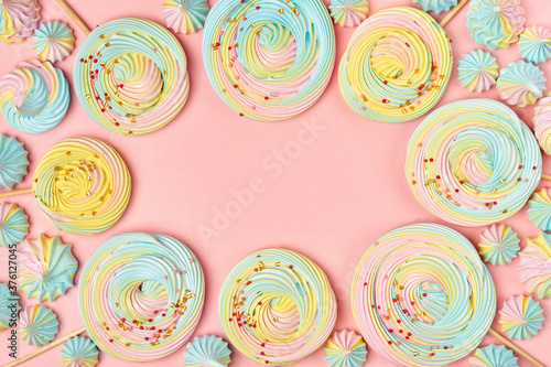 Sweets background frame made of meringue kisses and lollipops . Top view with copy space