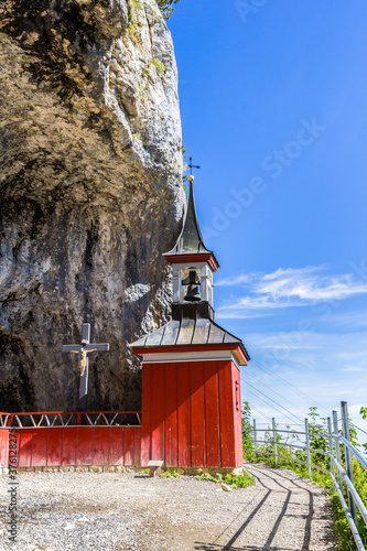 A little red wooden chapel on the hiking path on the Ebenalp mount, Appentell, Switzerland photo