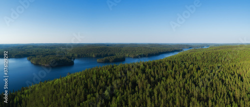 Aerial top down view of beautiful river. Birds eye view of scenic blue river with islands surrounded by forest. 