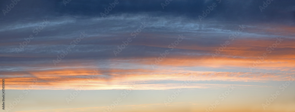 Fototapeta premium sky panorama with gray and orange clouds, above blue sky
