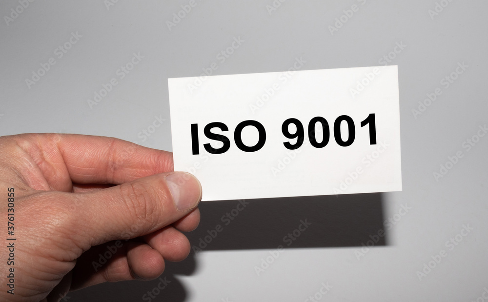 Message on the card ISO 9001, in hands of businessman. Message on the card ISO 9001, in hands of businessman.