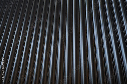 Black iron tin fence lined background. Metal texture