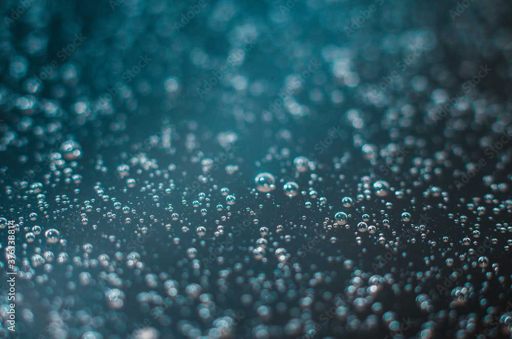 Dark blue background of air bubbles on the water surface. Close-up shot of air bubbles in liquid. Selective focus.