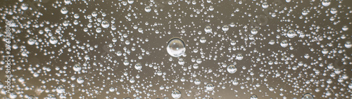 Panoramic photo background of air bubbles on the water surface. Close-up shot of air bubbles in liquid. Selective focus.