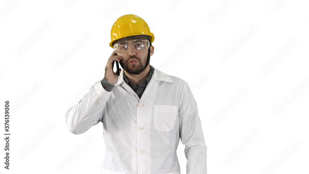 Engineer in protective glasses and hat walking, taking on the phone on white background. Engineer in protective glasses and hat walking, taking on the phone on white background.