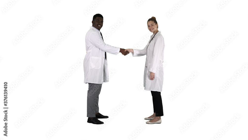 Doctors shaking hands and posing to camera on white background.