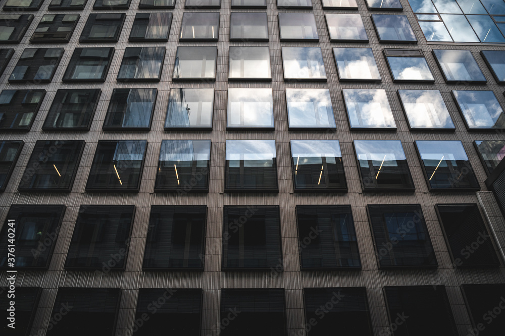 Modern office building in the city with blue sky and clouds reflection Modern office building in the city with blue sky and clouds reflection